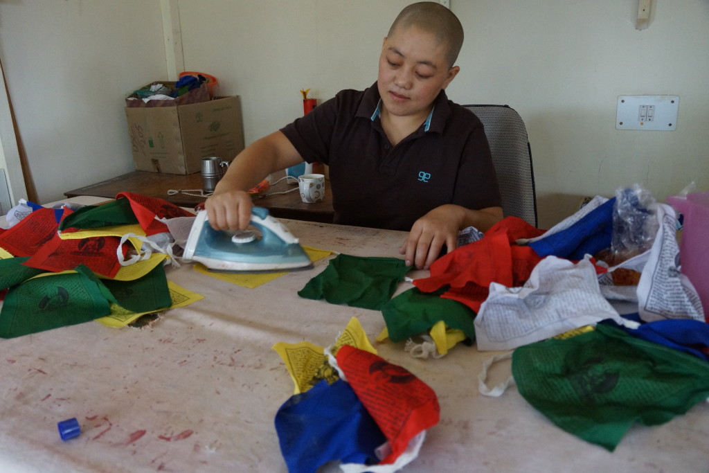Tibetan Buddhist nun making prayer flags