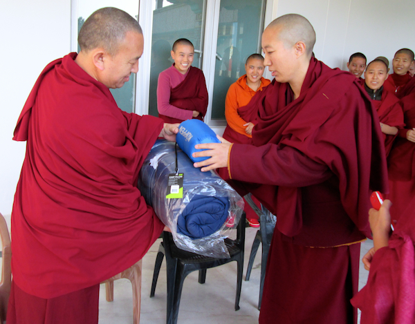 Tibetan Buddhist nun receiving gift of sleeping bag