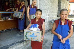 Tibetan Buddhist nuns carrying boxes