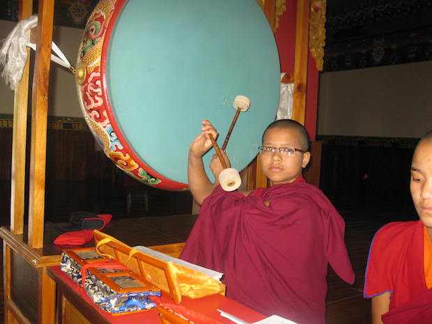 young Tibetan Buddhist nun performs a puja at Tilokpur