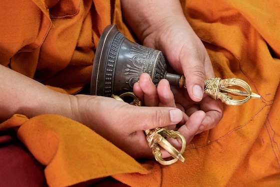 A Tibetan Buddhist nun holds a traditional bell and dorje.