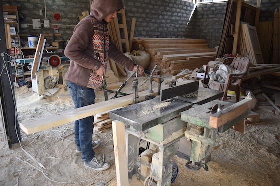 A carpenter prepares wood panelling for the nunnery.