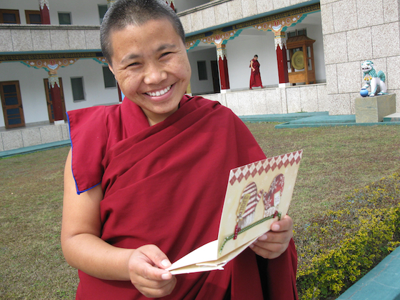 Tibetan Buddhist Nun at Sakya College for Nuns holding card from her sponsor