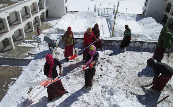 Tibetan Buddhist nuns at Sherab Choeling clear the roof from snow