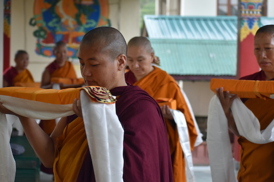 Tibetan Buddhist nuns at Shugsep Nunnery holding sacred texts as part of a puja
