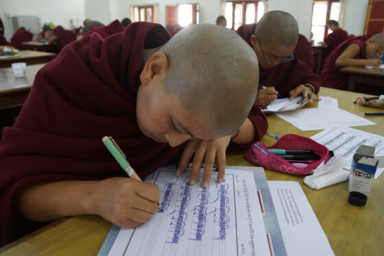 Tibetan Buddhist nun practices Tibetan calligraphy