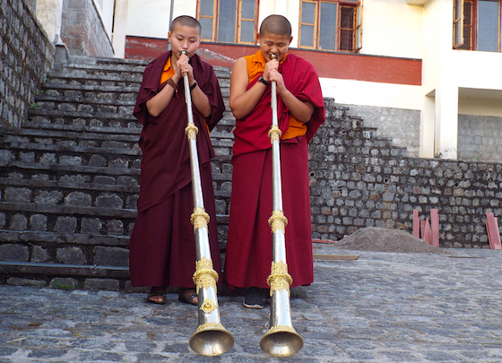 Two Tibetan Buddhist nuns play the dungchen, Tibetan long horns