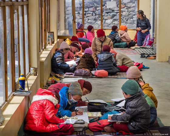 Tibetan Buddhist nuns and girls studying in the solarium of the new building at Dorjee Zong