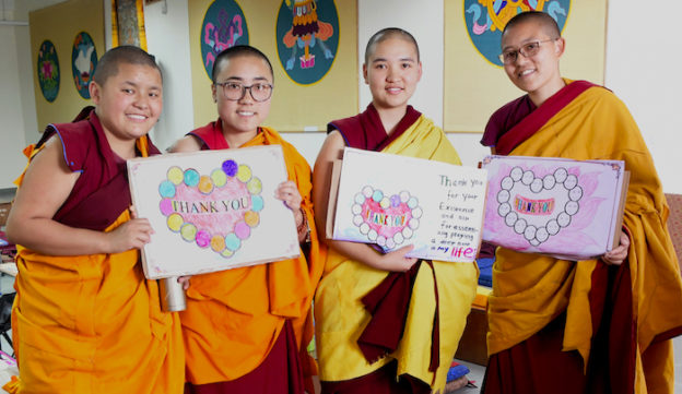 Reports on major projects, Tibetan Buddhist nuns hold thank you signs
